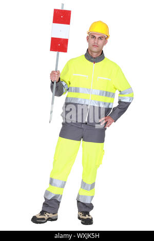 construction worker in safety outfit holding construction sign Stock Photo