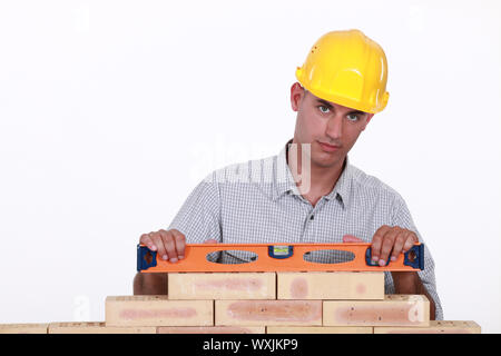 Bricklayer using a bubble level Stock Photo