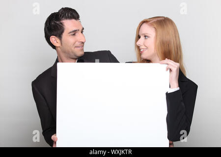 Man and woman smiling with panel in hand Stock Photo