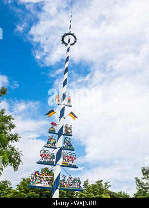 Picture of a typical traditional bavarian maypole with blue sky and white clouds Stock Photo