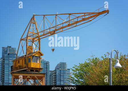 Old yellow vintage industrial loading crane on Granville Island, Vancouver, British Columbia, Canada Stock Photo