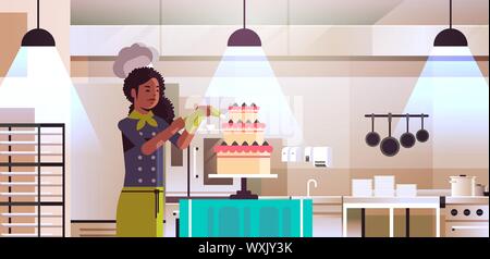 female professional chef pastry cook decorating tasty wedding cream cake african american woman in uniform cooking food concept modern restaurant Stock Vector