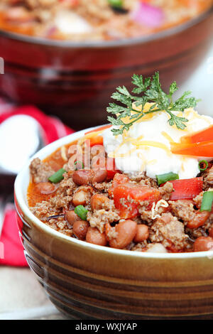 Chili Con Carne served with cheddar cheese and sour cream. Stock Photo
