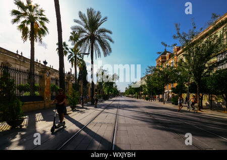 Seville, Spain - Sept 9, 2019: Pedestrians and people on scooters on San Fernando street in Andalusia Sevilla, Spain on a sunny summer afternoon Stock Photo
