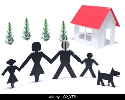 A paper family is holding hands beside their new paper house. Stock Photo