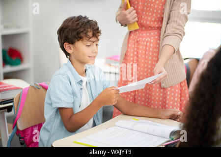 Dark-haired boy taking his test during the lesson Stock Photo