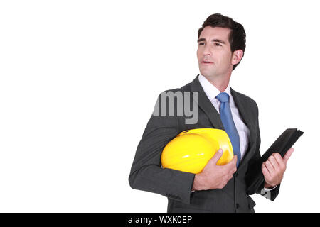 Man in a suit and helmet with folder Stock Photo