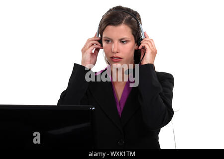 Receptionist putting her headset on Stock Photo