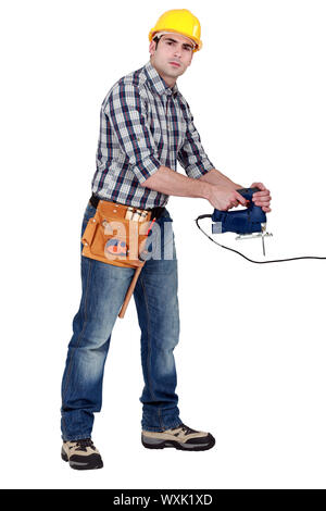 full-length shot of young carpenter using sander machine Stock Photo