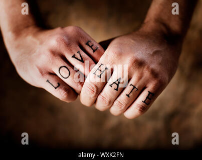 Man with (fake) Love and Hate knuckle tattoos. Stock Photo