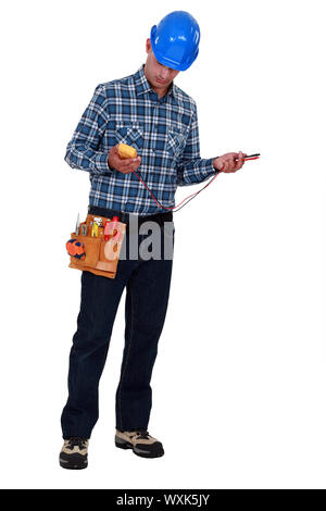 A male electrician checking a voltmeter. Stock Photo