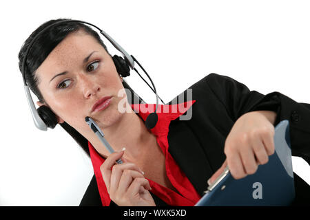 receptionist with headset and side look taking a call Stock Photo