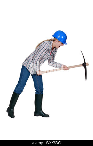 Tradeswoman using a pickaxe Stock Photo