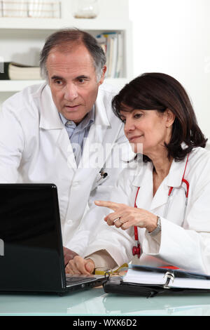 Doctors looking at a computer and sharing their opinions Stock Photo