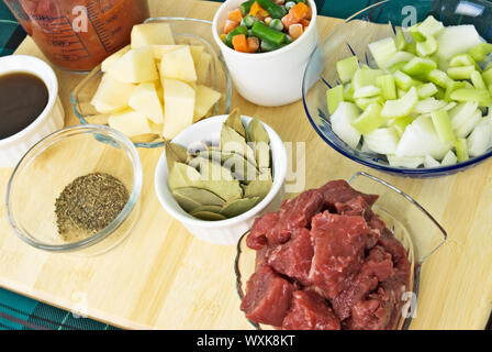 Food ingredients needed for making beef and vegetable soup. Includes red trimmed beef stew meat, celery and onion, egetables, potatoes Stock Photo