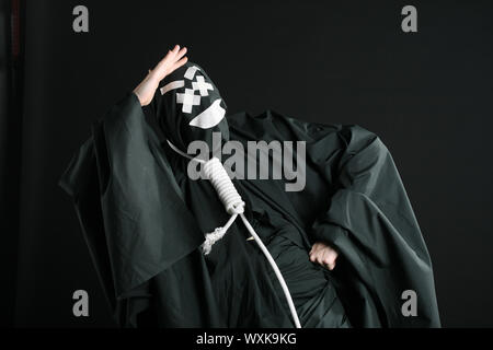 Black mime with rope on neck on black background Stock Photo