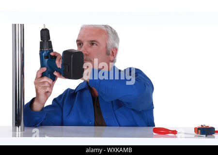 Man putting up a shelf Stock Photo