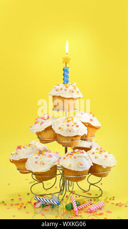 Cupcakes on multi-tierd stand with candle on yellow background Stock Photo