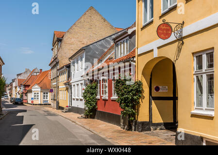 Picturesque  street in Faaborg with old houses and hollyhocks on the pavement, Faaborg, Denmark, July 12, 2019 Stock Photo