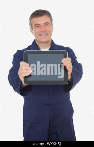 Mature mechanic showing digital tablet over white background Stock Photo