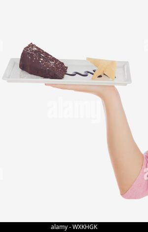 Closeup of hand holding plate of tempting pastry against white background Stock Photo