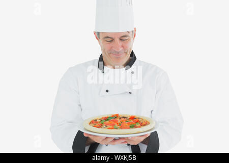 Mature chef holding pizza over white background Stock Photo