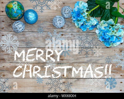 Christmas postcard frame with whit wood background. For greeting card.. Xmas wallpaper, Blue glitter balls and turquoise flowers. Stock Photo