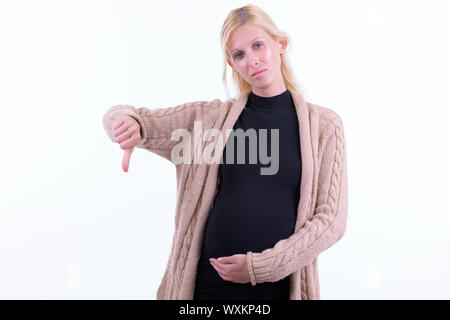 Stressed young blonde pregnant woman giving thumbs down Stock Photo