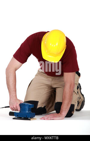 Builder using sander on floor Stock Photo
