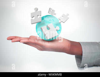 Hand with digital white puzzles and a globe Stock Photo