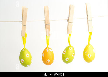 Four easter eggs hanging from a line from wooden pegs Stock Photo