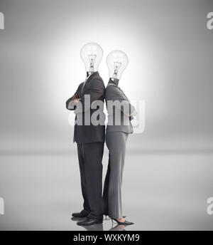 Business people with light bulbs instead of heads standing back to back Stock Photo