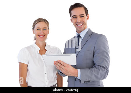 Smiling co workers using a tablet pc on white background Stock Photo