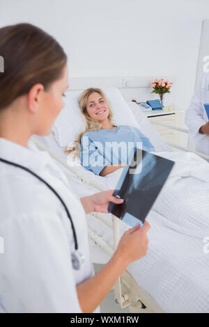 Doctor holding a radiography and standing next to a smiling patient Stock Photo