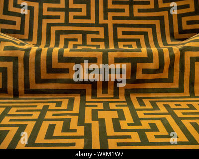 Black angular lines on an orange fabric background, ancient greek labyrinth pattern Stock Photo