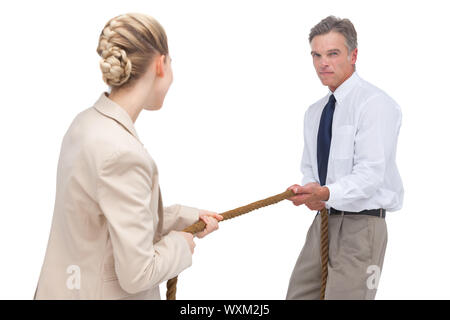 portrait of businesswoman pulling colleagues tie at workplace with ...