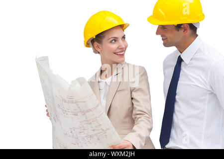 Two architects looking at each other while holding construction plan Stock Photo