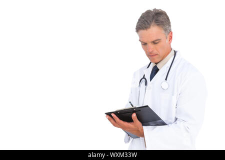 Man doctor holding clipboard and writing something Stock Photo