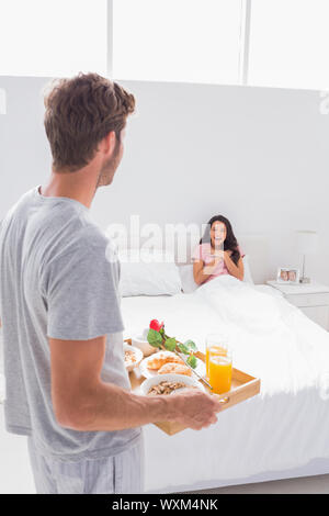 Surprising her with breakfast. A young man bringing his girlfriend