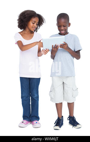 Brother and sister using tablet pc on a white background Stock Photo