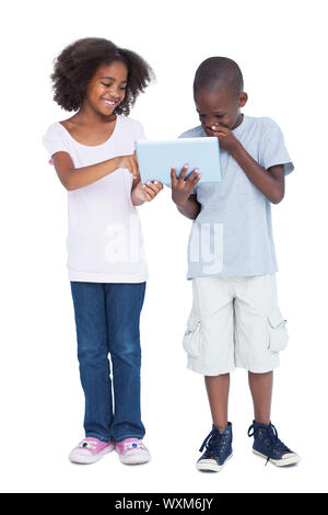 Laughing boy looking at tablet pc with his sister Stock Photo
