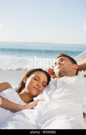 Peaceful couple sleeping in a hammock on the beach Stock Photo