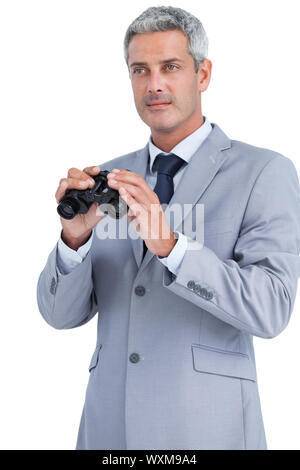 Businessman posing with binoculars on white background Stock Photo