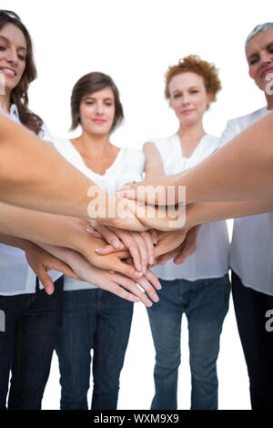 Relaxed models joining hands in a circle on white background Stock Photo
