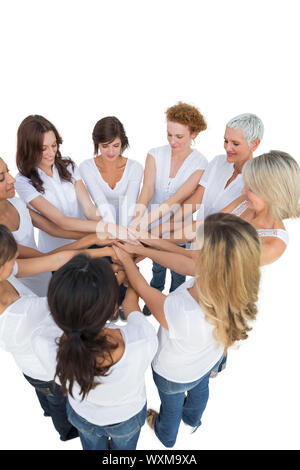Happy female models joining hands in a circle on white background Stock Photo