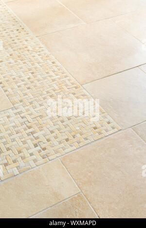 Porcelain floor tiles with a stone mosaic design in a neutral cream colour Stock Photo