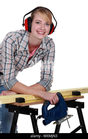 Female carpenter wearing protective muffs Stock Photo
