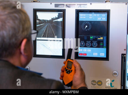 17 September 2019, Saxony, Schlettau: Thomas Kayser, a railcar driver from the military and transport company Thales, controls a railcar during a test drive at Schlettau station using a mobile suitcase with cockpit and route information. The train is remotely controlled by him via the new 5G mobile radio standard. Vodafone has built one of the first 5G stations in Germany at the station in Schlettau. In the future, trains could be controlled remotely, for example in freight transport. The research train is part of the Smart Rail Connectivity Campus project led by Chemnitz University of Technol Stock Photo