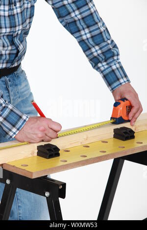 Carpenter measuring a plank Stock Photo