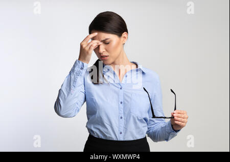 Overworked Businesswoman Massaging Nosebridge Having Ocular Hypertension Over White Background Stock Photo